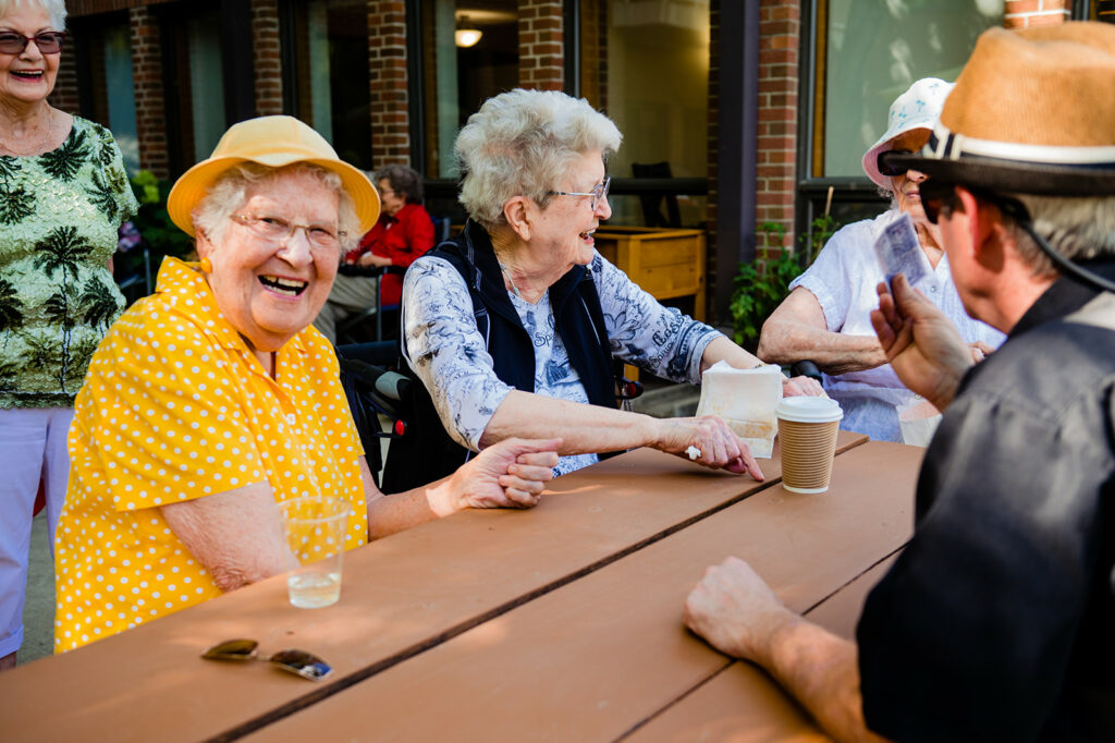 Women enjoying a laugh together on a patio.