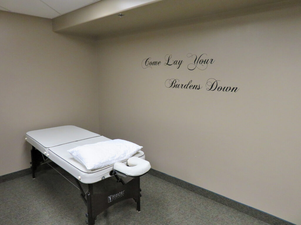 The Massage Therapy room at Bethany. The text on the wall reads, "Come Lay Your Burdens Down."