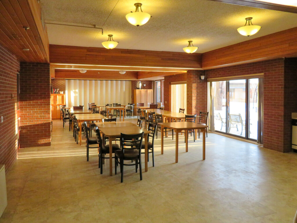 The Manor Multi-Purpose Room with tables and chairs set up for activities and visiting.